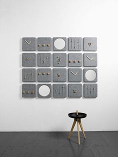 the wall is made up of square and round pieces with different earrings hanging on them