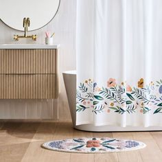 a bathroom with a rug, sink and mirror on the floor in front of it