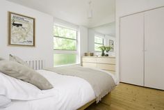 a bedroom with white walls and wooden floors