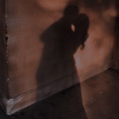 the shadow of a person standing in front of a wall