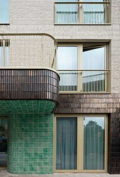 an apartment building with balconies and green tiles