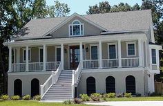 a large white house with stairs leading up to the front door and second story porch