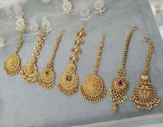 several gold necklaces are displayed on a table