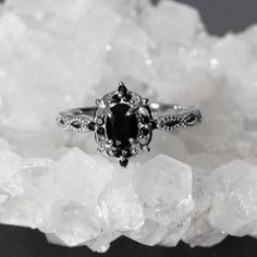 a black and white diamond ring sitting on top of some ice crystals in front of the camera