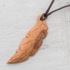 Evoking freedom a floating feather is hand-carved from a single piece of light brown jobillo wood with a beautiful natural grain. Costa Rica's Milagro Cascante creates this pendant necklace which circles the neck with an adjustable length of cotton cord. Floating Feather, Wooden Feather, Wood Feather, Woodcarving Ideas, Carving Jewelry, Feather Pendant Necklace, Cotton Necklace, Buy Wood, Wood Necklace