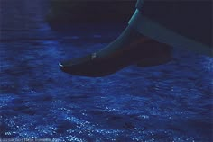 two boats in the water at night with blue lights on them and one boat is upside down