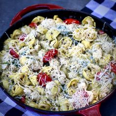 a pan filled with pasta and cheese on top of a checkered table cloth