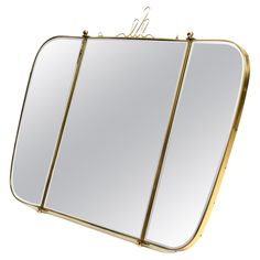 a mirror that is sitting on top of a stand with two mirrors hanging from it's sides