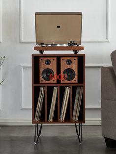 an old record player with vinyls and records in it's storage unit next to a couch