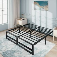 a metal bed frame sitting on top of a wooden floor next to a white chair