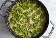 a pot filled with rice and vegetables on top of a table