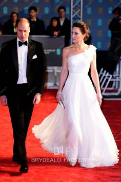 a man in a tuxedo walking next to a woman in a white dress