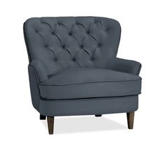 a dark blue chair with wooden legs and buttoned backrests on an isolated white background