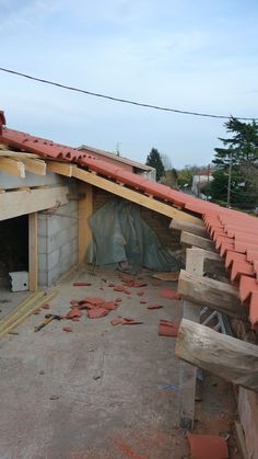 an unfinished building with red roof tiles on the top and side walls that have been torn off