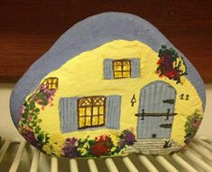 a painted rock with a house on it