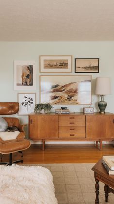 a living room filled with furniture and pictures on the wall