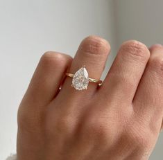 a woman's hand with a diamond ring on it