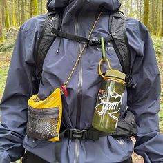 a man in the woods with his back pack and water bottle strapped to his waist