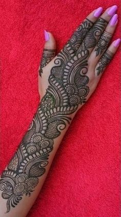 a woman's hand with henna tattoos on it