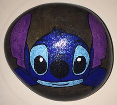 a blue and purple painted rock sitting on top of a white table