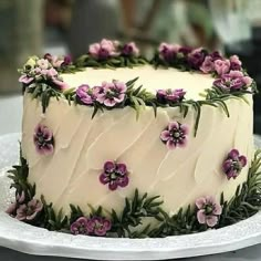 a white cake with purple flowers on it