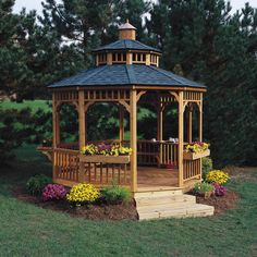 a wooden gazebo surrounded by flowers and trees