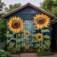 an outhouse with sunflowers painted on the side and behind it is a garden shed