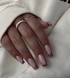 a woman's hand with pink and white manies on her nails, wearing a ring