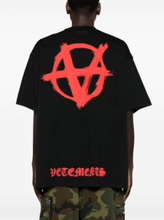 Find VETEMENTS Reverse Anarchy Cotton T-shirt on Editorialist. black, bright red cotton soft jersey crew neck Reverse Anarchy logo print at the chest and rear drop shoulder short sleeves embroidered logo to the rear straight hem unlined When buying this unisex item, keep in mind that it is graded in standard men's sizing. Red Punk T-shirt For Streetwear, Red Logo T-shirt With Short Sleeves, Oversized Black Logo Top, Oversized Black T-shirt With Logo, Edgy Red Graphic Print T-shirt, Red Graffiti Print T-shirt For Streetwear, Edgy Relaxed Fit T-shirt With Logo Print, Red Logo Tops For Streetwear, Punk Crew Neck T-shirt With Logo Print