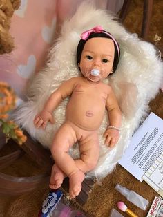 a baby doll with a pacifier sitting on a chair