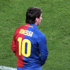 a man standing on top of a soccer field wearing a blue and red uniform with the number 10 on it