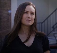 a woman with long hair standing in front of stairs