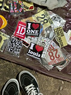 a pair of black and white shoes sitting on top of a bag filled with stickers