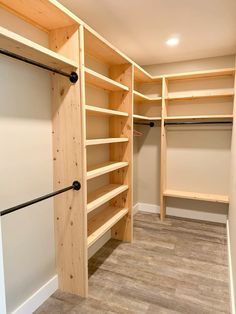 an empty walk in closet with wooden shelves