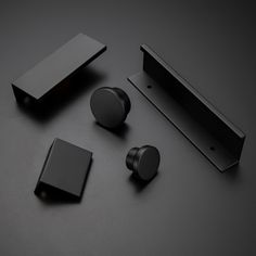 an assortment of black items on a dark surface, including earbuds and magnets