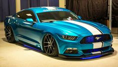 a blue mustang car with white stripes on it