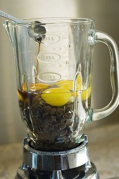 a glass blender filled with liquid and lemons