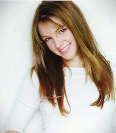 a woman with long hair is smiling for the camera