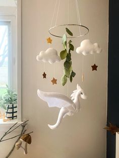 a mobile made to look like a flying bird with stars and clouds hanging from the ceiling