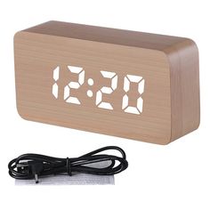 a wooden clock with the time displayed on it's face and power cord plugged in