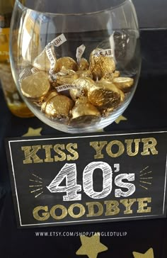 a sign that says kiss your 40's goodbye in front of some gold coins