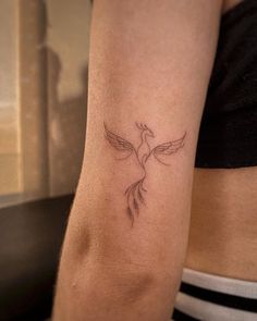 a woman's arm with a bird tattoo on it