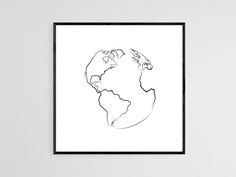 a black and white drawing of the earth is shown in a frame on a wall