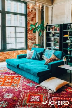 a living room filled with lots of furniture next to a large window and bookshelf