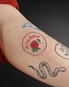 a woman's arm with tattoos on it and a rose in the center that says,