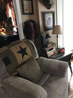 a living room with two couches and pictures on the wall above them in front of a window