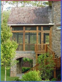 a stone house with a wooden porch and stairs