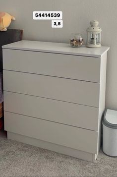 a white chest of drawers sitting next to a night stand with a stuffed animal on top