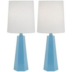 two blue table lamps with white shades on them