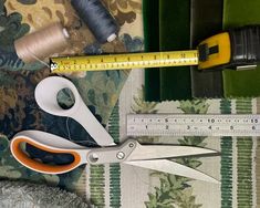 scissors, measuring tape and needle on fabric